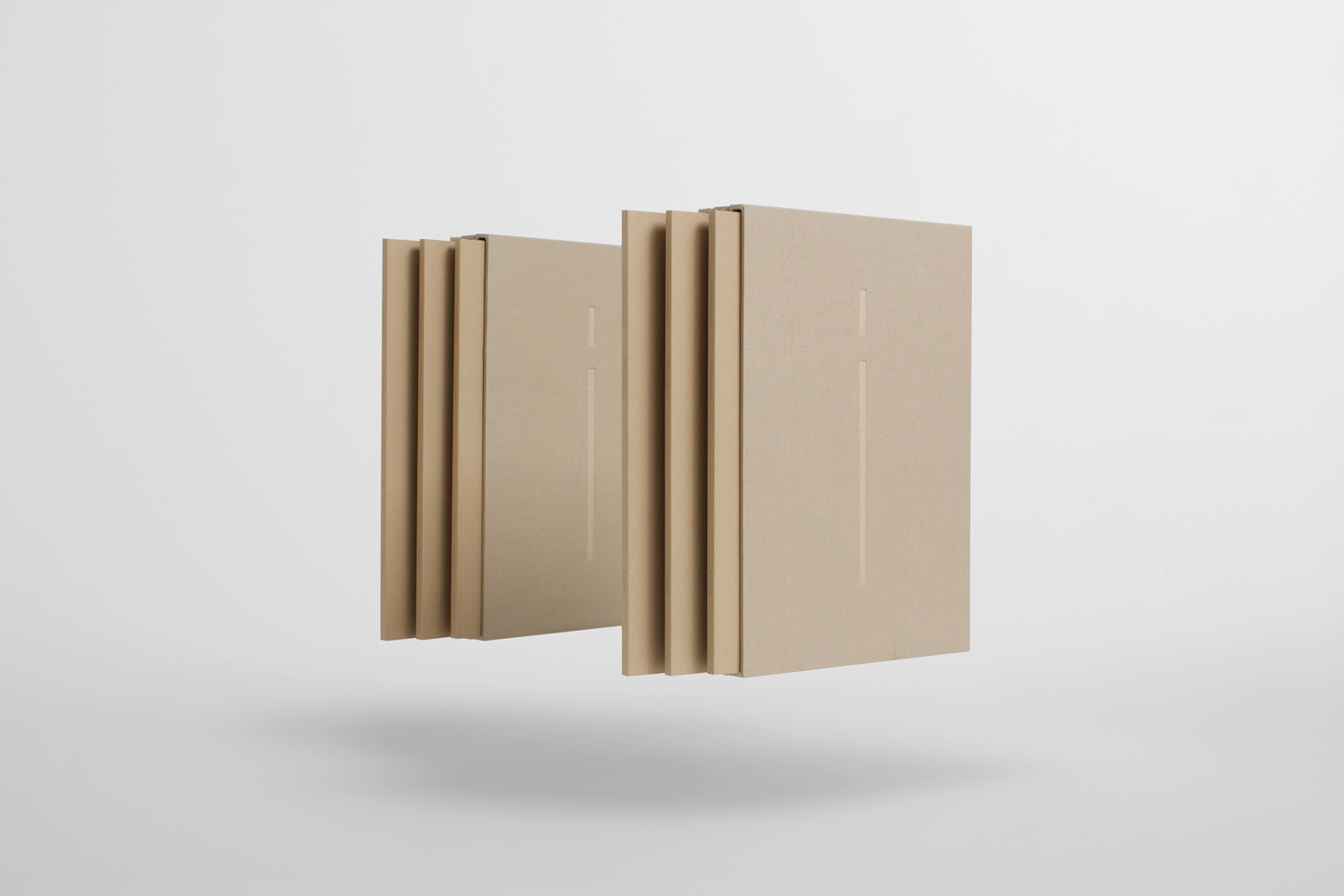 Floating beige book sets against a clean light grey studio background for brand identity