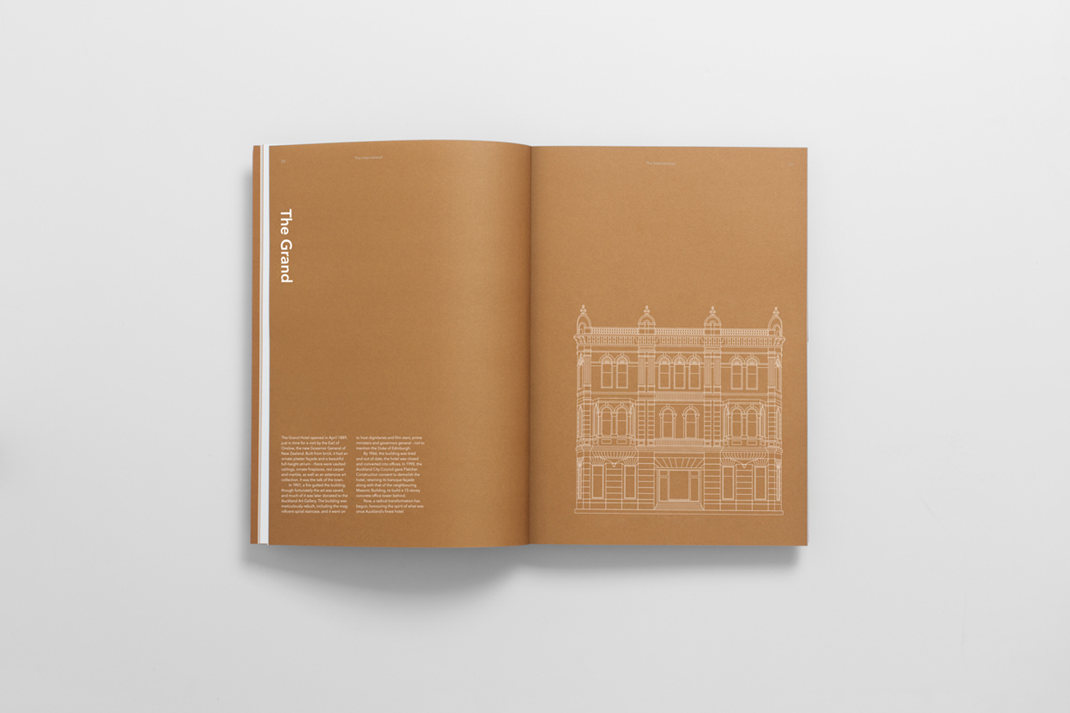 An open brand identity brochure featuring brown pages with white typography and architectural line drawings against a plain white background.