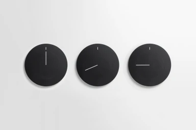 Three minimalist black circular wall clocks with white hands arranged horizontally against a plain white background.