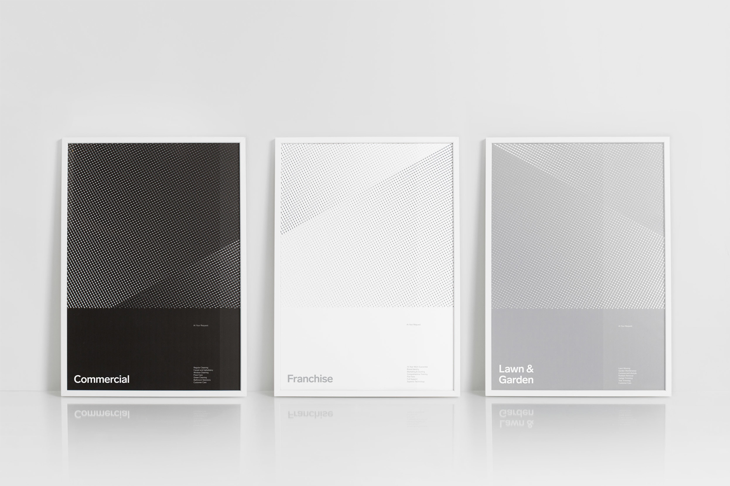 Three framed graphic posters with halftone dot patterns and typography leaning against a white studio wall.