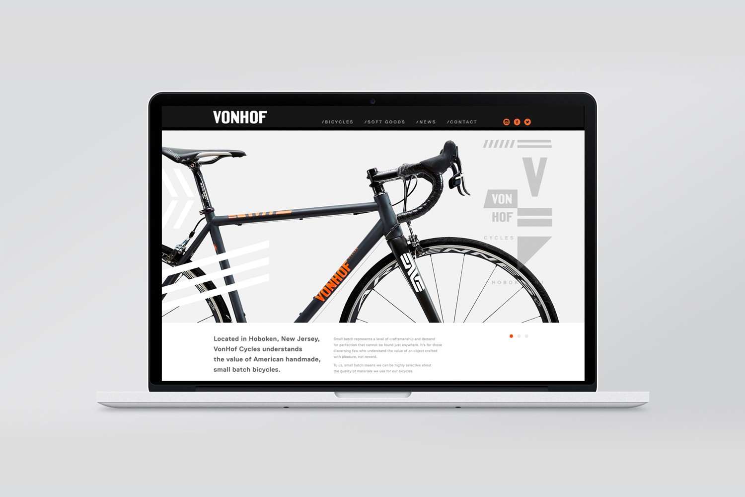 A laptop displaying a modern bicycle website with grey frame and orange typography against a clean light grey background