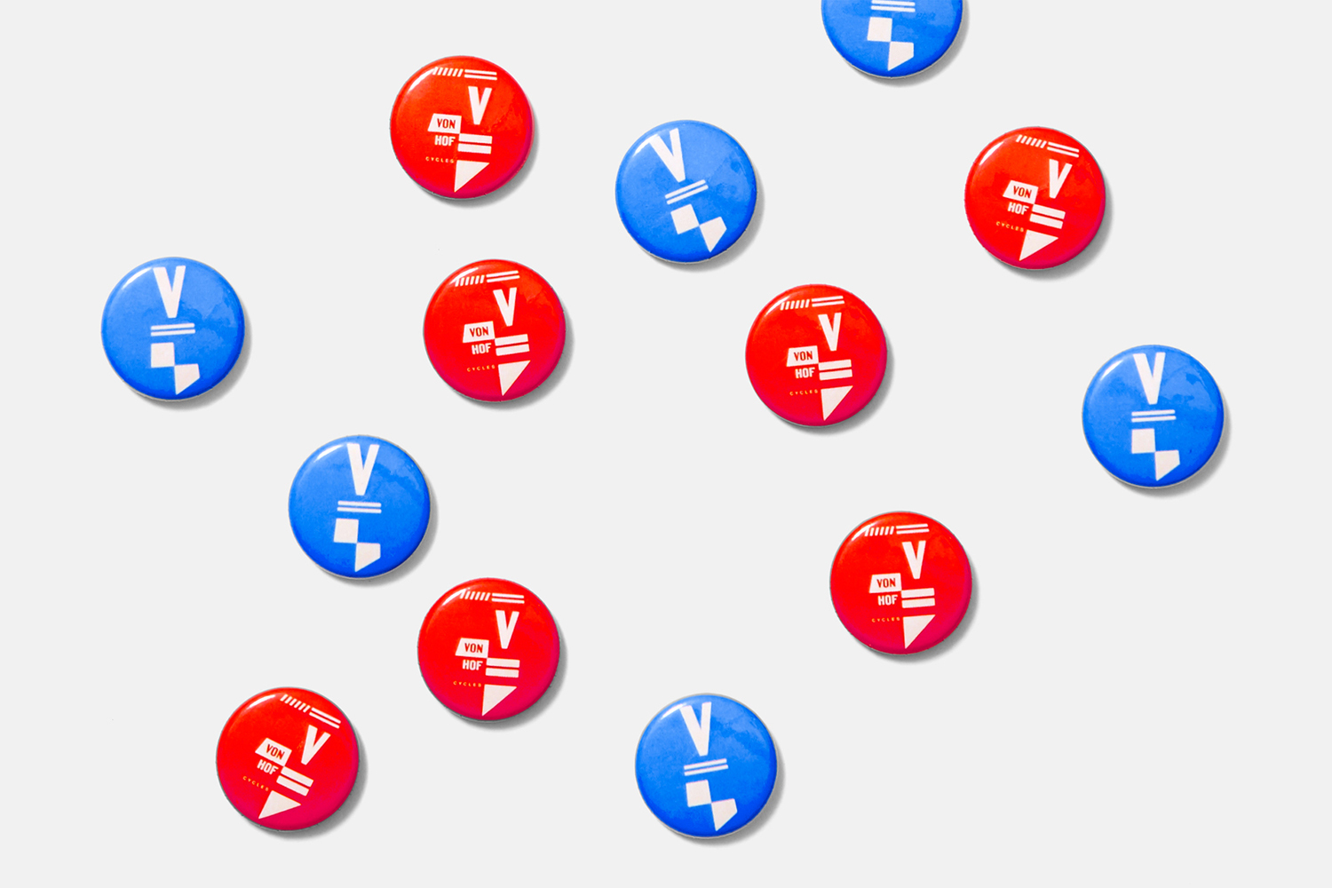 A collection of red and blue circular badges with white graphic designs arranged flat on a light grey background.