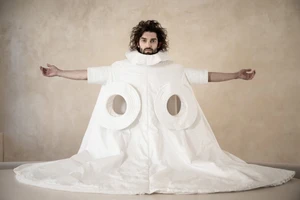 Man wearing a sculptural white quilted garment with circular cutouts for the Dzhus Anticon ad campaign