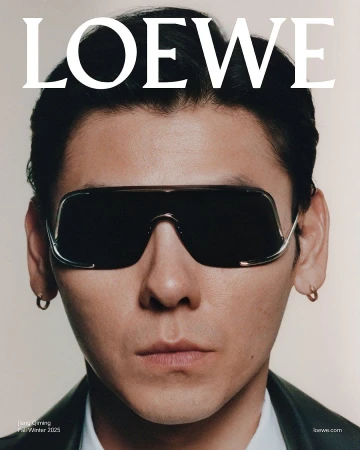 Close-up portrait of Jiang Qiming wearing dark shield sunglasses and earrings against a neutral background for Loewe.