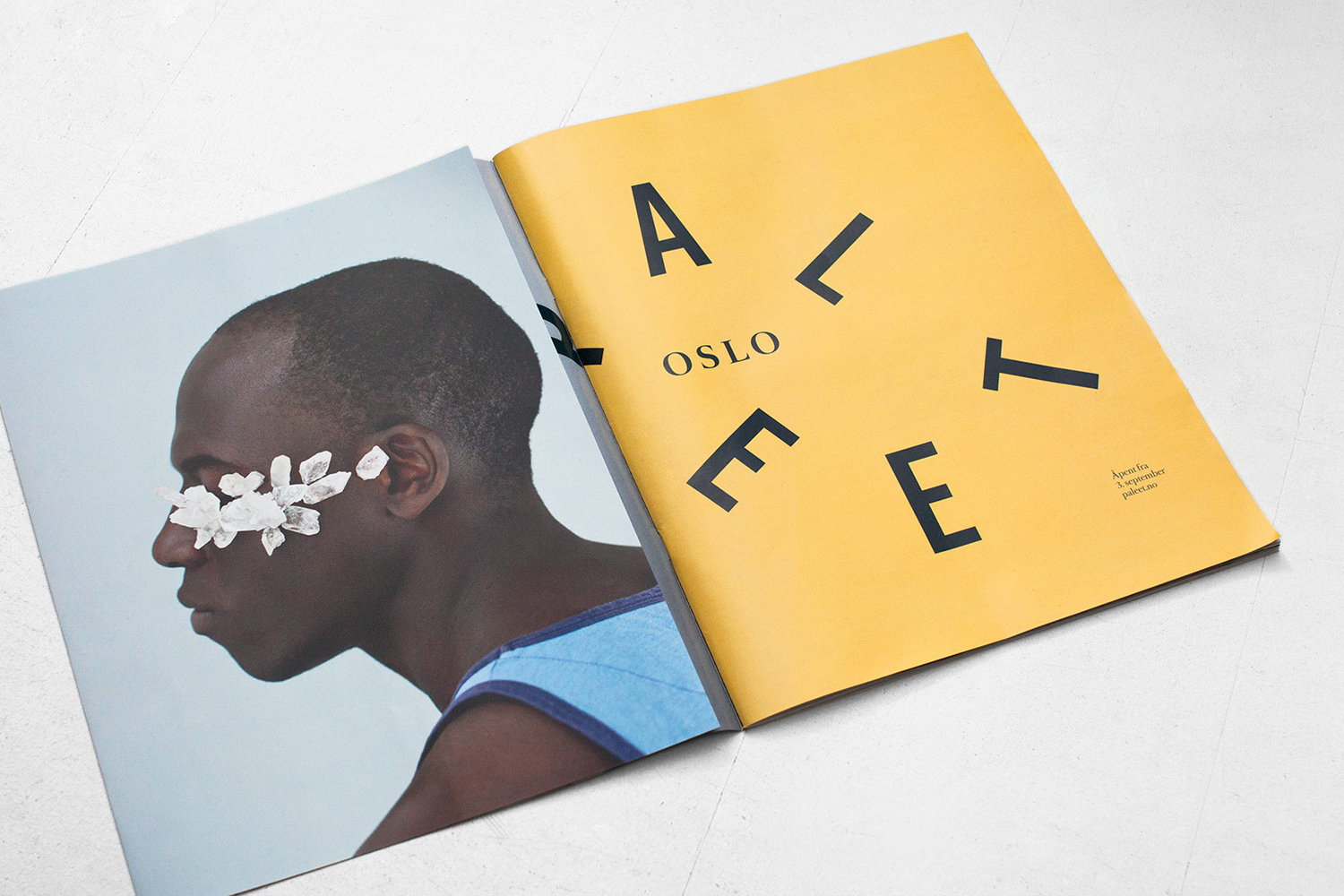 An open magazine showing a portrait of a Black man with crystals over his eye on the left page and bold typography on the right.