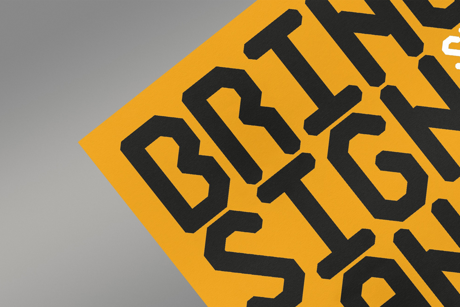 Close-up of bold dark typography against a vibrant yellow and grey background from a brand identity project.