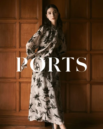 Woman wearing a patterned long-sleeve dress standing against dark wood paneling with white text overlay
