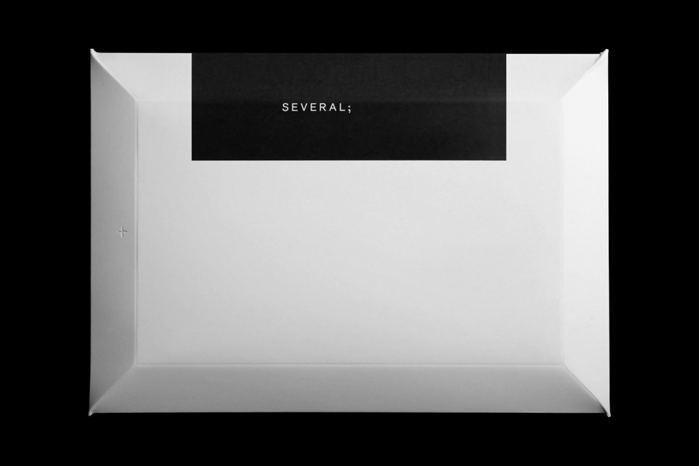 Minimalist graphic design brand identity layout with a white rectangular paper tray and a black label bearing the text SEVERAL;