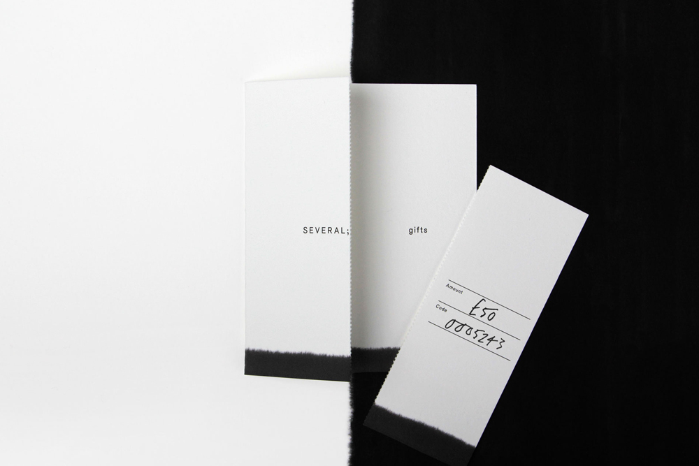 Minimalist graphic design identity for Several showing folded white paper cards with black typography against a split background