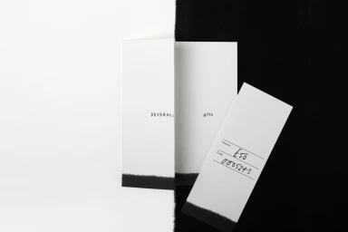 Minimalist graphic design identity for Several showing folded white paper cards with black typography against a split background
