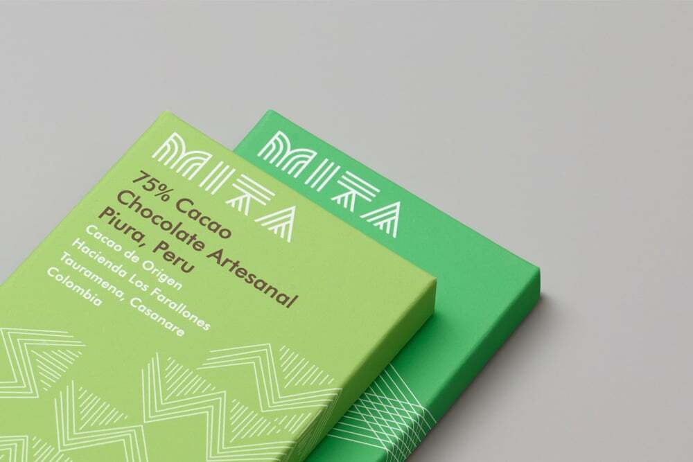Two green Mita Chocolate Co. packaging boxes resting on a light grey seamless background.