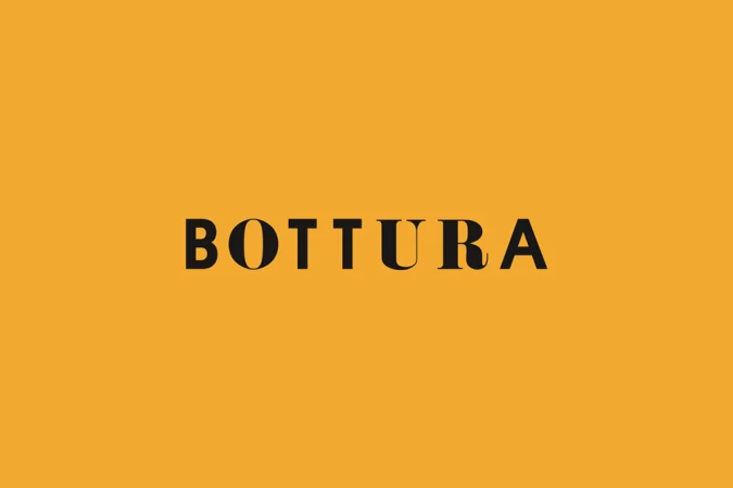 Black serif typography spelling Bottura centered against a solid mustard yellow background.