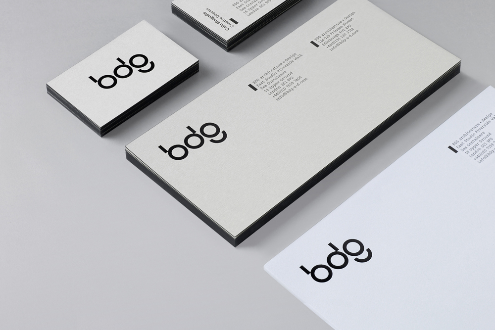 Minimalist corporate stationery set featuring business cards and letterhead with the BDG brand logo on white paper.