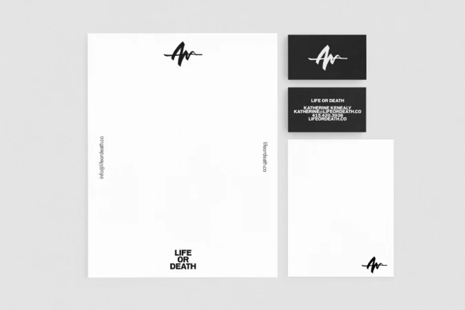 Flat lay of corporate stationery including letterhead and business cards with Life or Death logo by DIA Studio