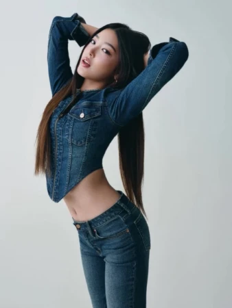 Woman posing in a fitted blue denim jacket and jeans against a plain white background for Gap Fall 2025 campaign.