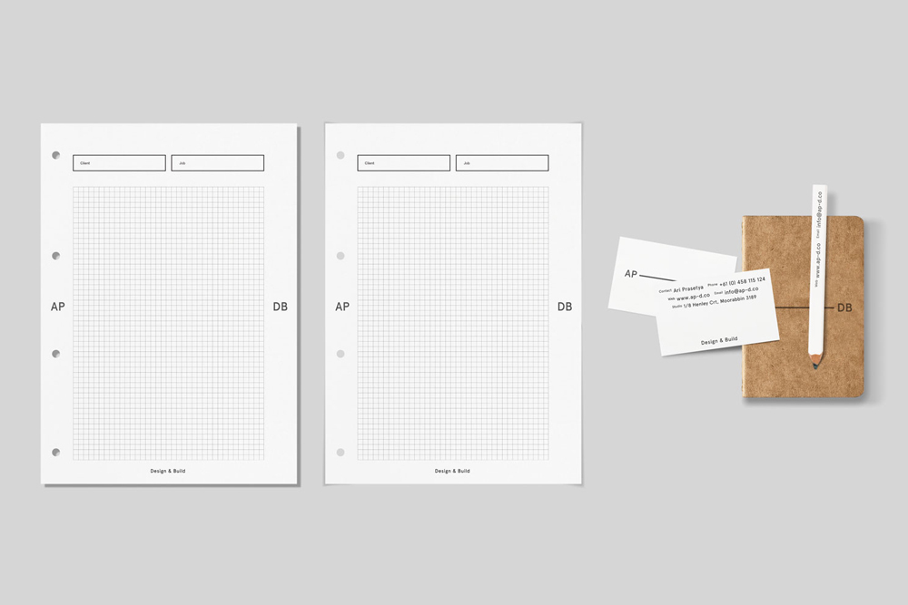 AP-DB brand identity stationery mockup showing graph paper sheets, business cards, a small notebook, and a white pencil.