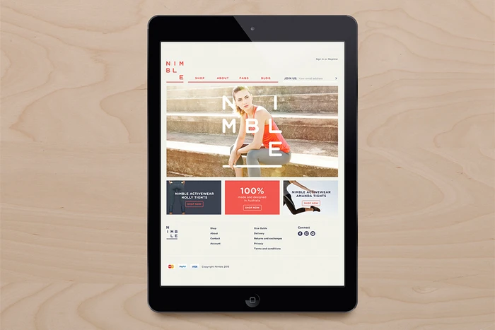 A tablet device displaying the Nimble activewear website on a light wood grain surface.
