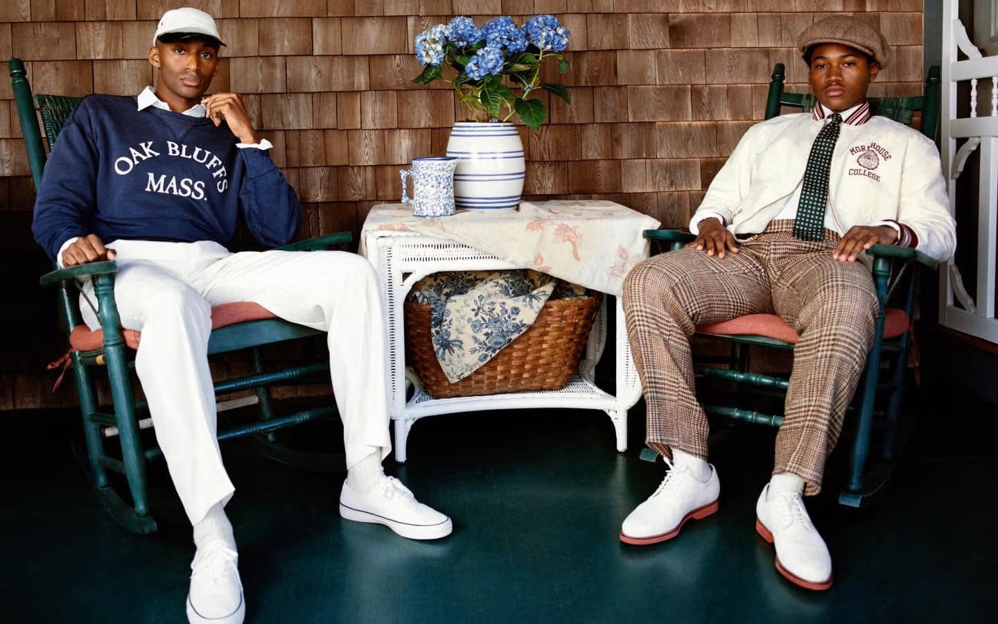 Two men seated in green rocking chairs on a porch wearing preppy apparel for Polo Ralph Lauren Oak Bluffs campaign photographed by Nadine Ijewere.