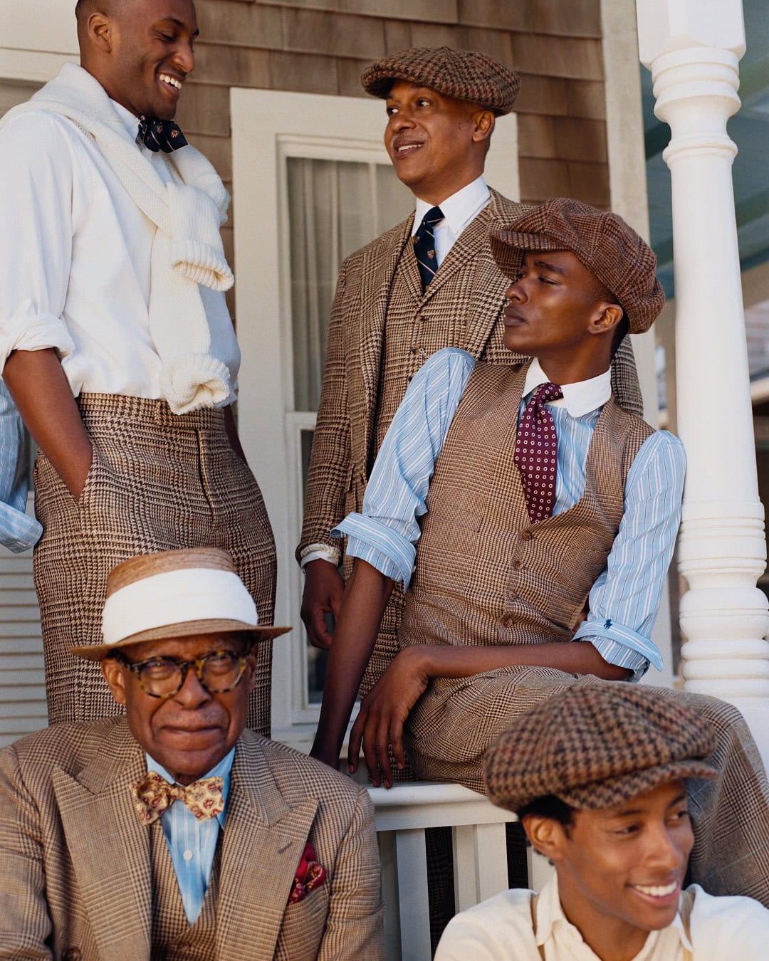 Five models in tailored tweed suits and caps posing together on a porch for Polo Ralph Lauren Oak Bluffs campaign.