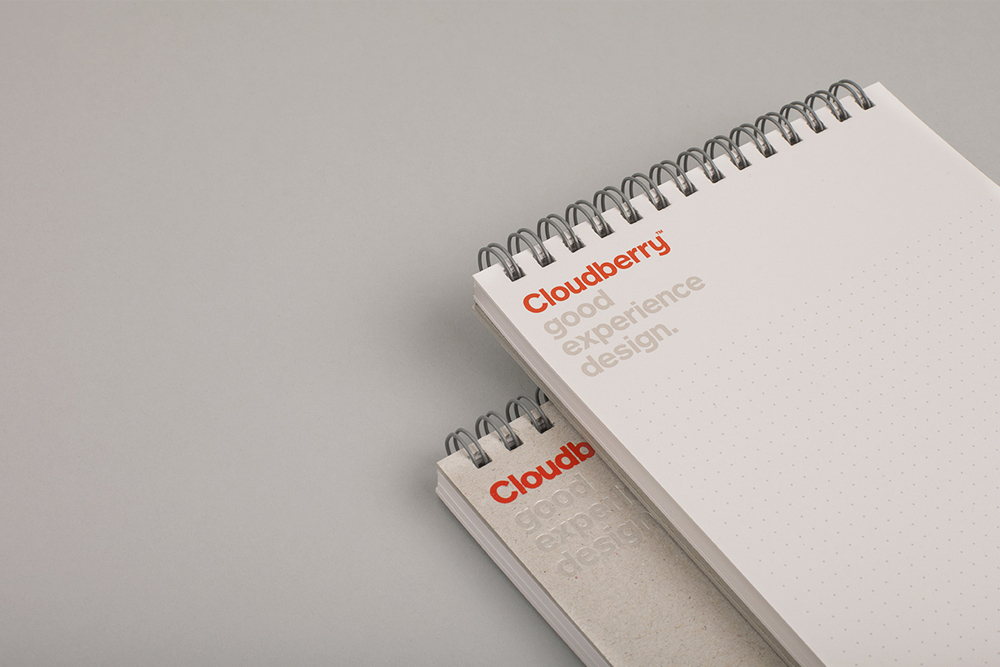 Two spiral-bound dot grid notebooks stacked on a plain grey surface with Cloudberry branding printed on the cover