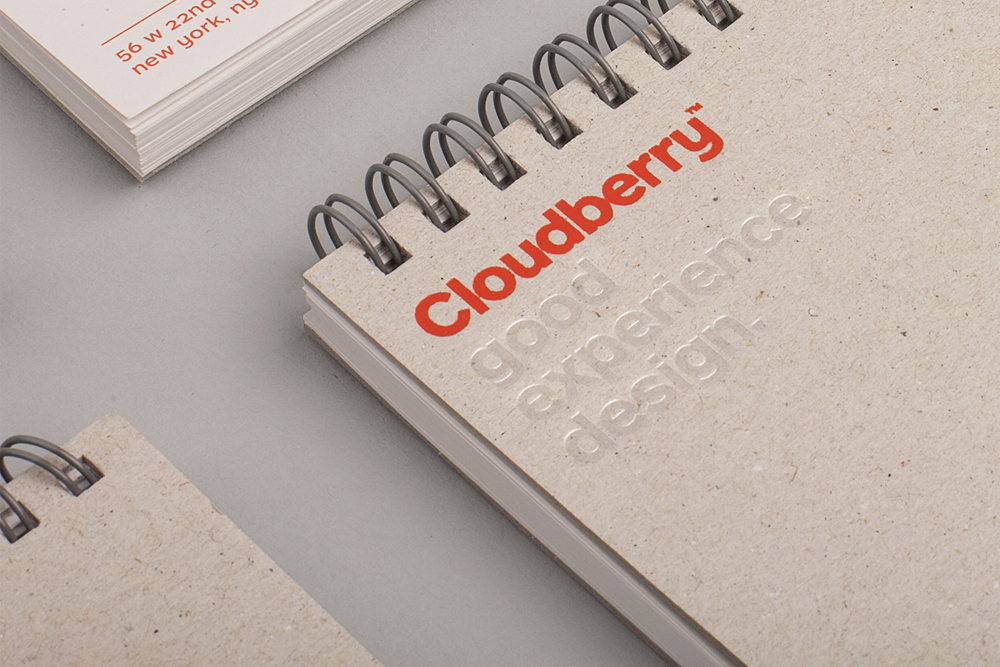Close-up of a spiral-bound notebook with Cloudberry logo and debossed typography on recycled paper cover.