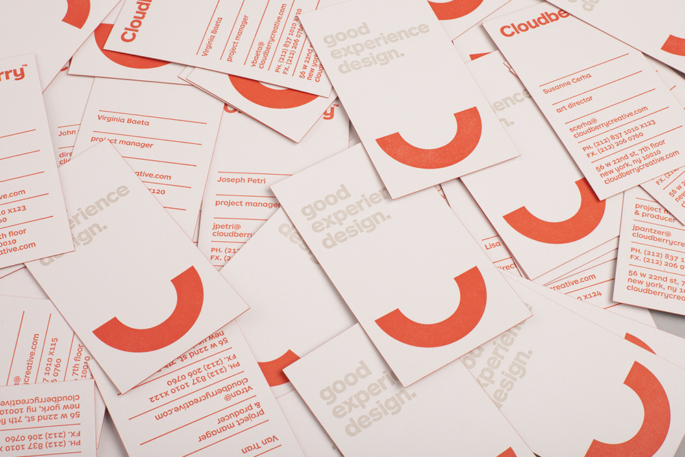 Scattered white business cards featuring orange semi-circle graphic elements and typography for Cloudberry.