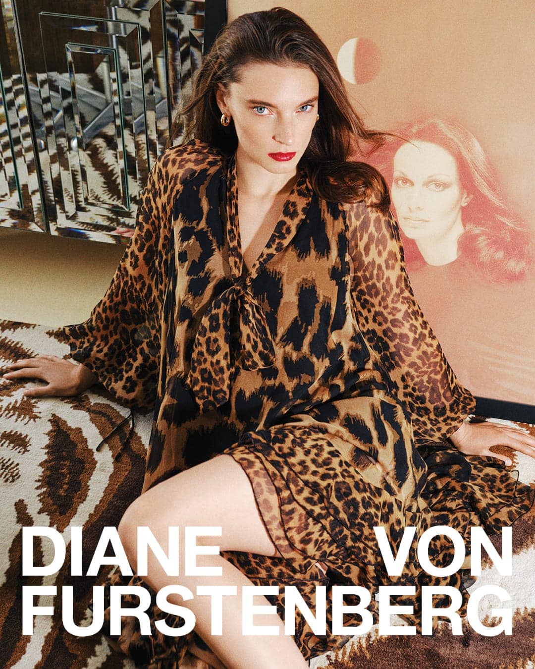 Model wearing a leopard print dress seated in an interior setting for Diane von Furstenberg Fall 2025 campaign.