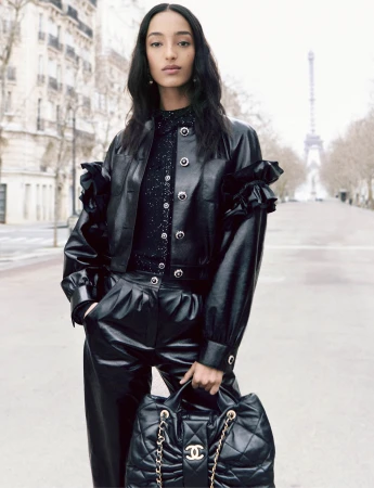 Mona Tougaard in a black leather jacket and trousers holding a quilted handbag on a Parisian street
