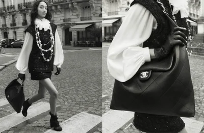Model Mona Tougaard walking down a cobblestone street wearing a tweed vest and holding a large leather handbag in a Chanel campaign