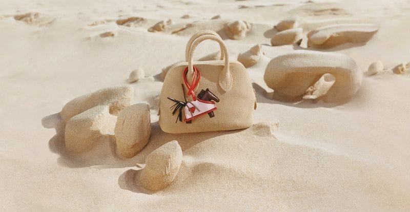 Hermes handbag crafted from sand placed on a sandy beach under bright daylight