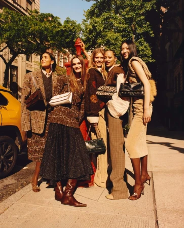 Five models posing together on a New York City street during the Tory Burch Fall 2025 ad campaign, photographed by Jamie Hawkesworth.