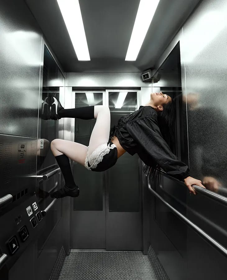Model Amelia Gray posing horizontally inside a metallic elevator for the Puma Mostro ad campaign