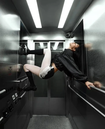 Model Amelia Gray posing horizontally inside a metallic elevator for the Puma Mostro ad campaign