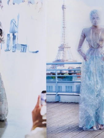 Model in sheer blue gown covered in translucent material on a wooden balcony with the Eiffel Tower in the background