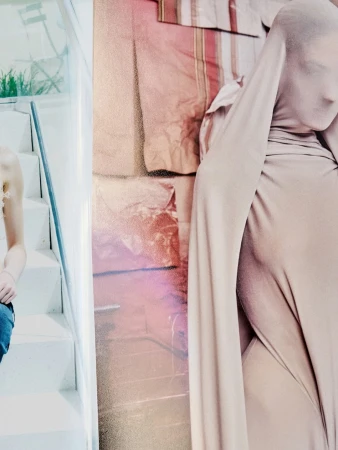 Model draped in beige fabric with face covered standing in front of a draped backdrop for Maison Margiela Artisanal Fall 2025 campaign