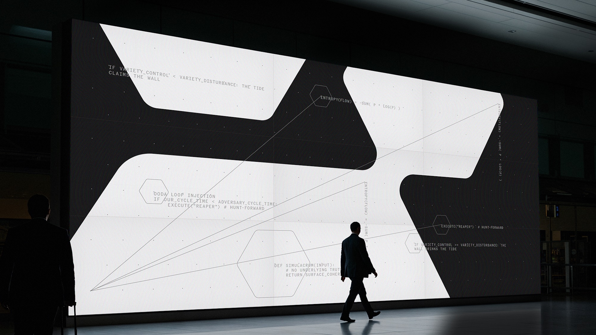 Man in dark suit walking in front of a massive abstract digital display screen showing geometric graphics and technical code text.