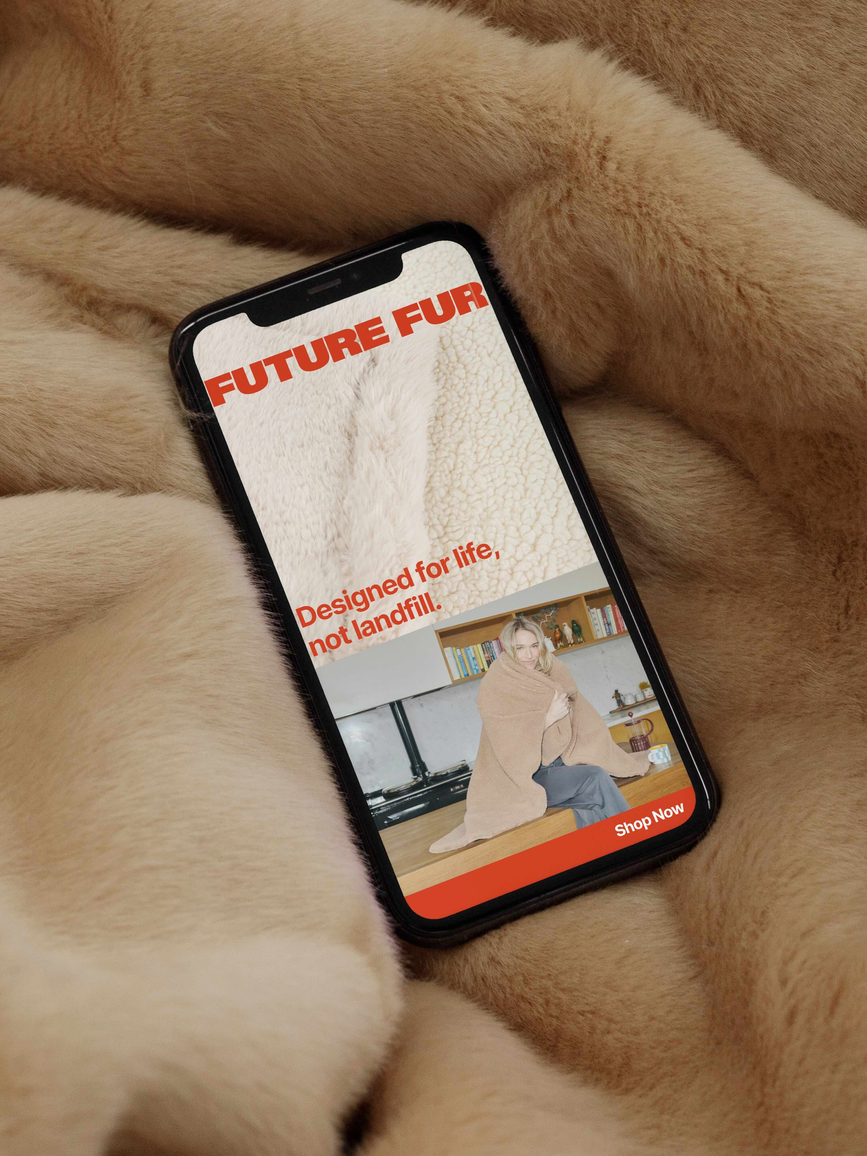 A smartphone resting on a tan faux fur blanket displaying the Future Fur brand identity design on screen.