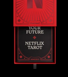 Top-down view of a bright red box containing a black card with white typography reading YOUR FUTURE NETFLIX TAROT.