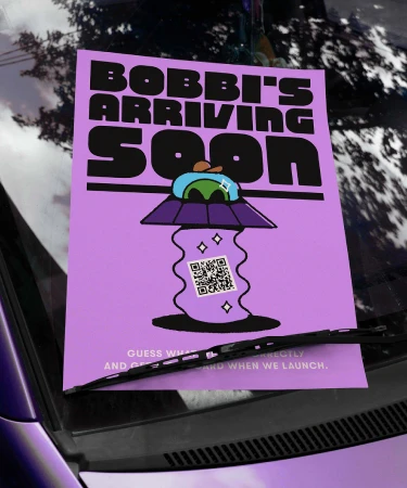 Purple promotional poster for Bobbis featuring a UFO graphic and QR code tucked under a car windshield wiper.