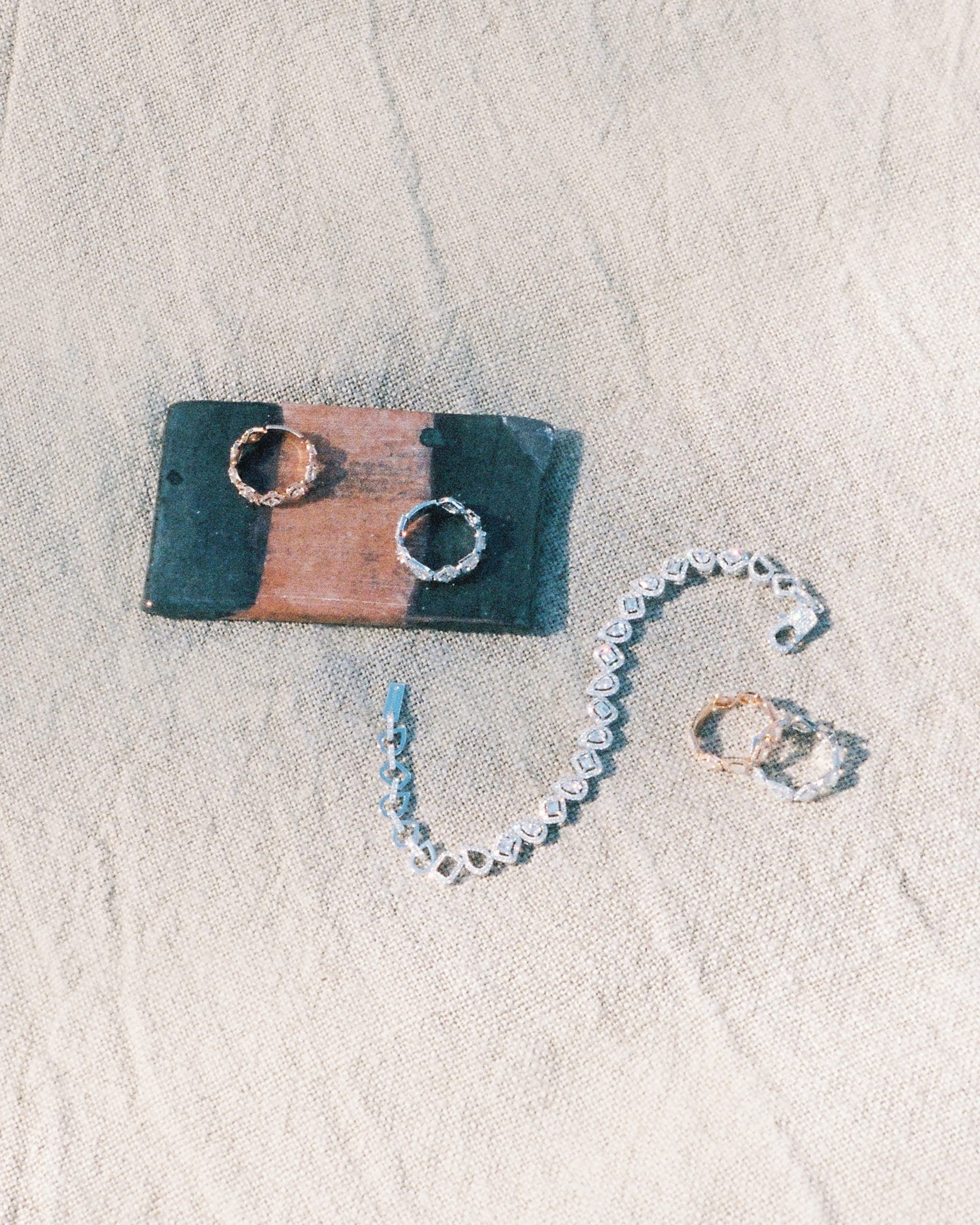 Messika diamond jewellery pieces displayed on textured sand and a stone block for the Summer 2025 campaign.