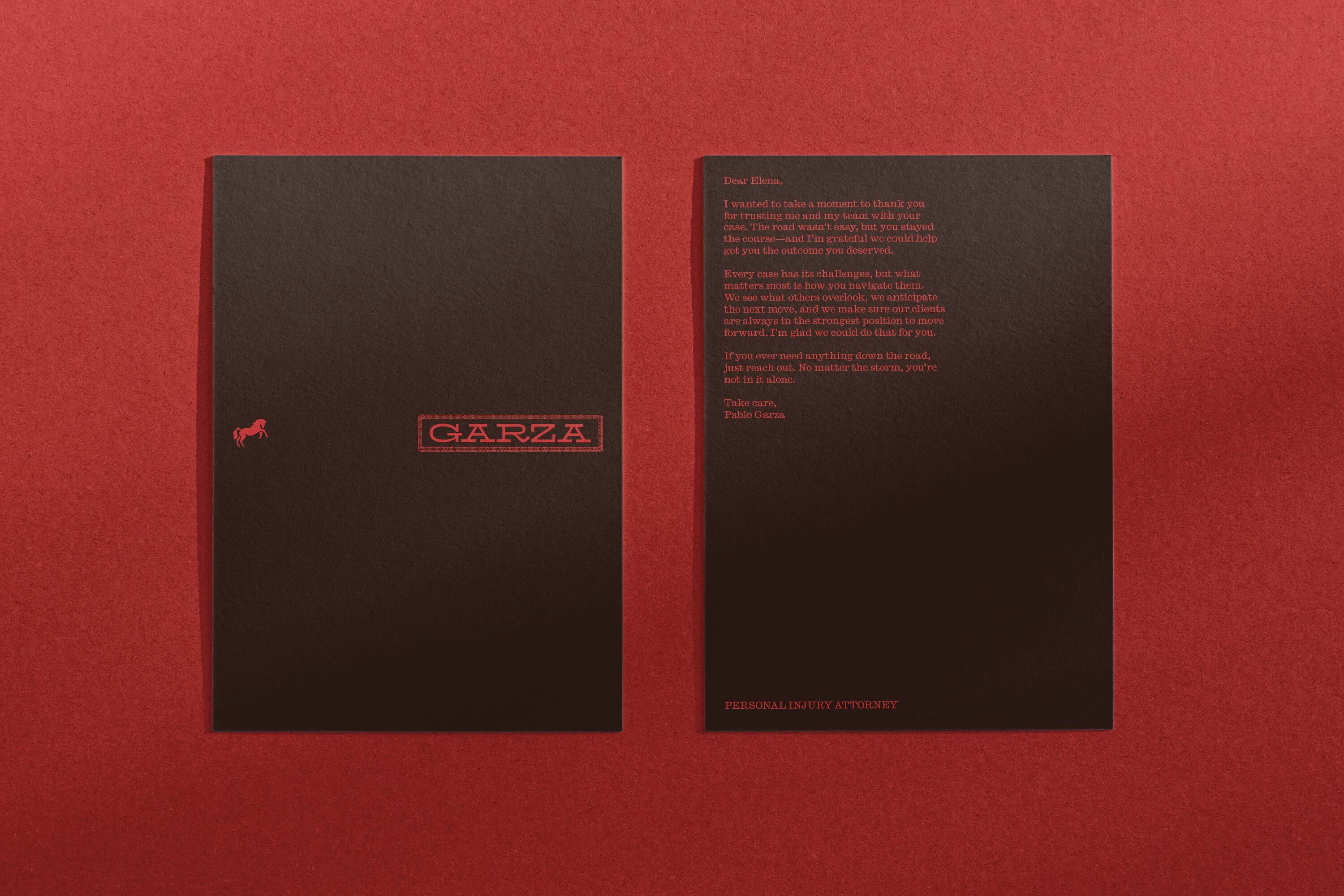 Two dark stationery cards with red lettering placed flat on a textured dark red surface.
