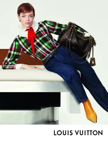 Emma Stone wearing plaid top and blue jeans leaning on furniture holding a dark shoulder bag for Louis Vuitton ad campaign