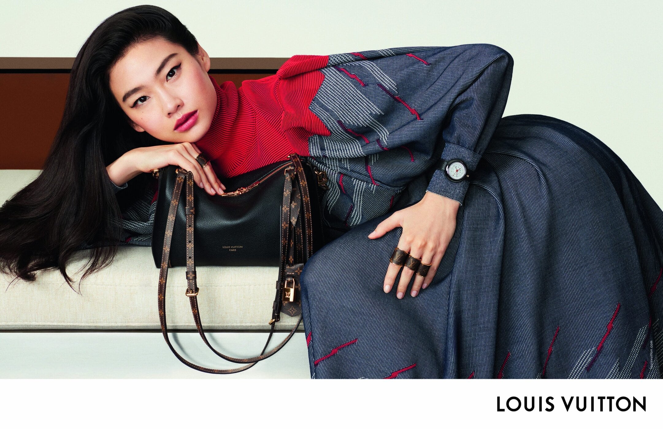 Model Hoyeon resting on a lounge holding a black handbag for Louis Vuitton Women's Fall 2025 Ad Campaign