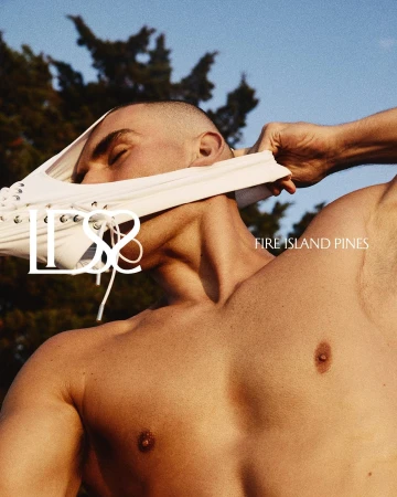 Shirtless male model wearing white lace-up briefs pulled over his face against an outdoor sky background