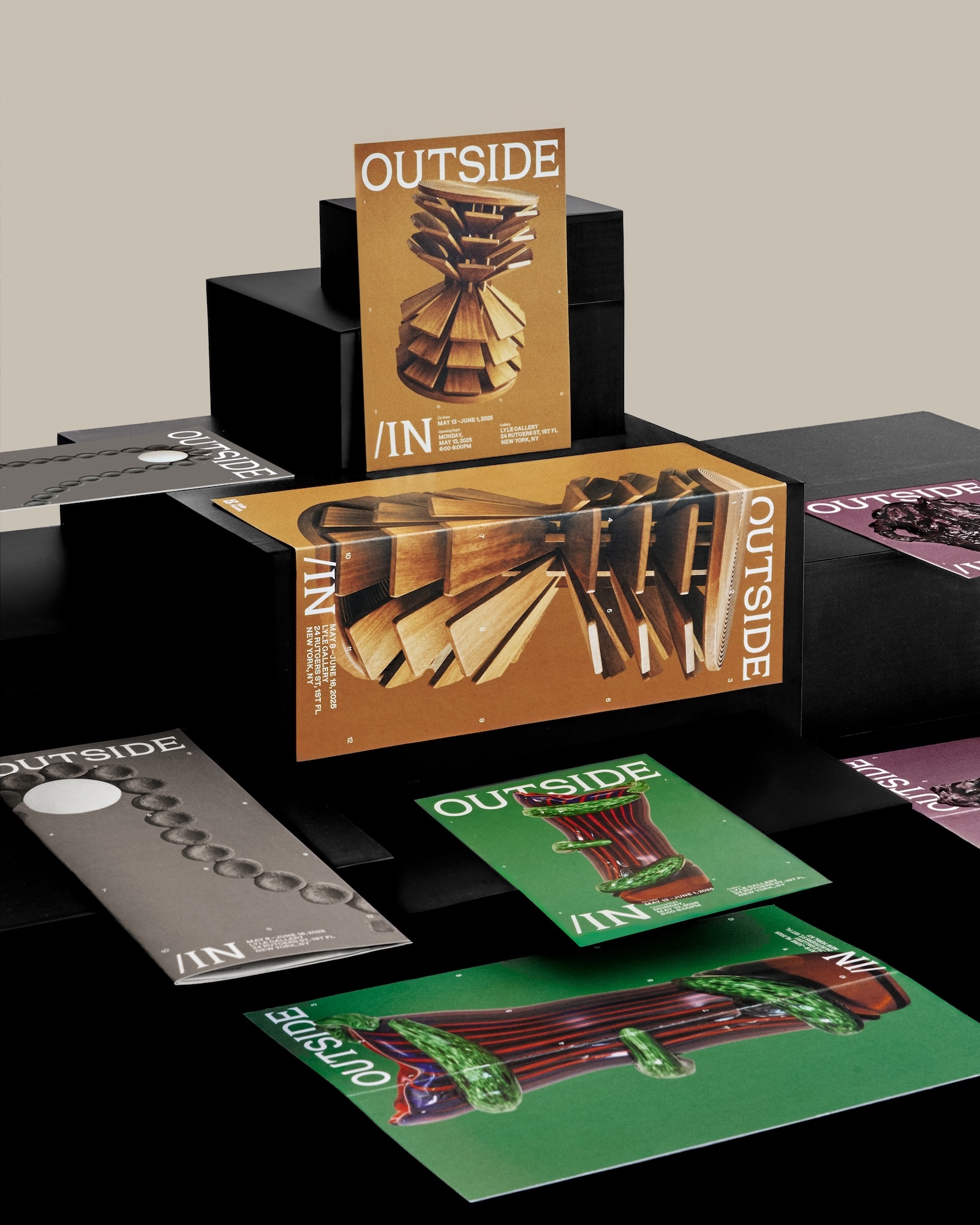 Printed publications and promotional cards displayed on tiered black blocks featuring graphic designs and photographs