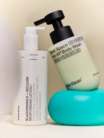 Two bottles of body wash and moisturising lotion from Hello Klean and Blank Space, displayed on a light background and blue podium.
