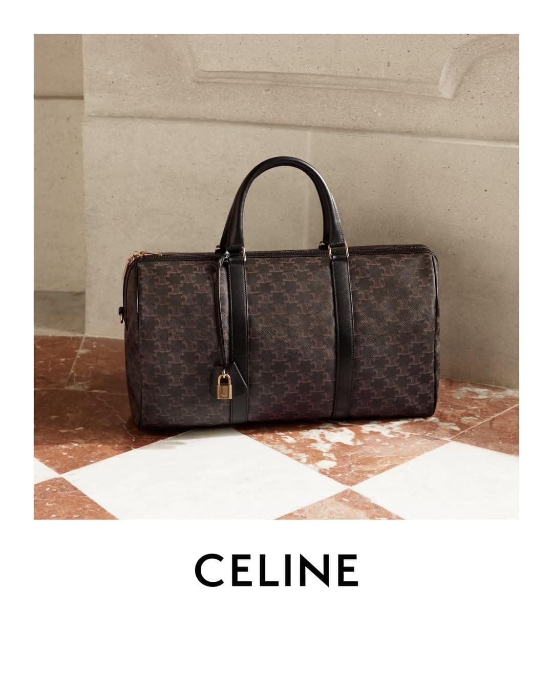 Celine monogram duffel bag with black leather handles resting on a red and white checkered marble floor