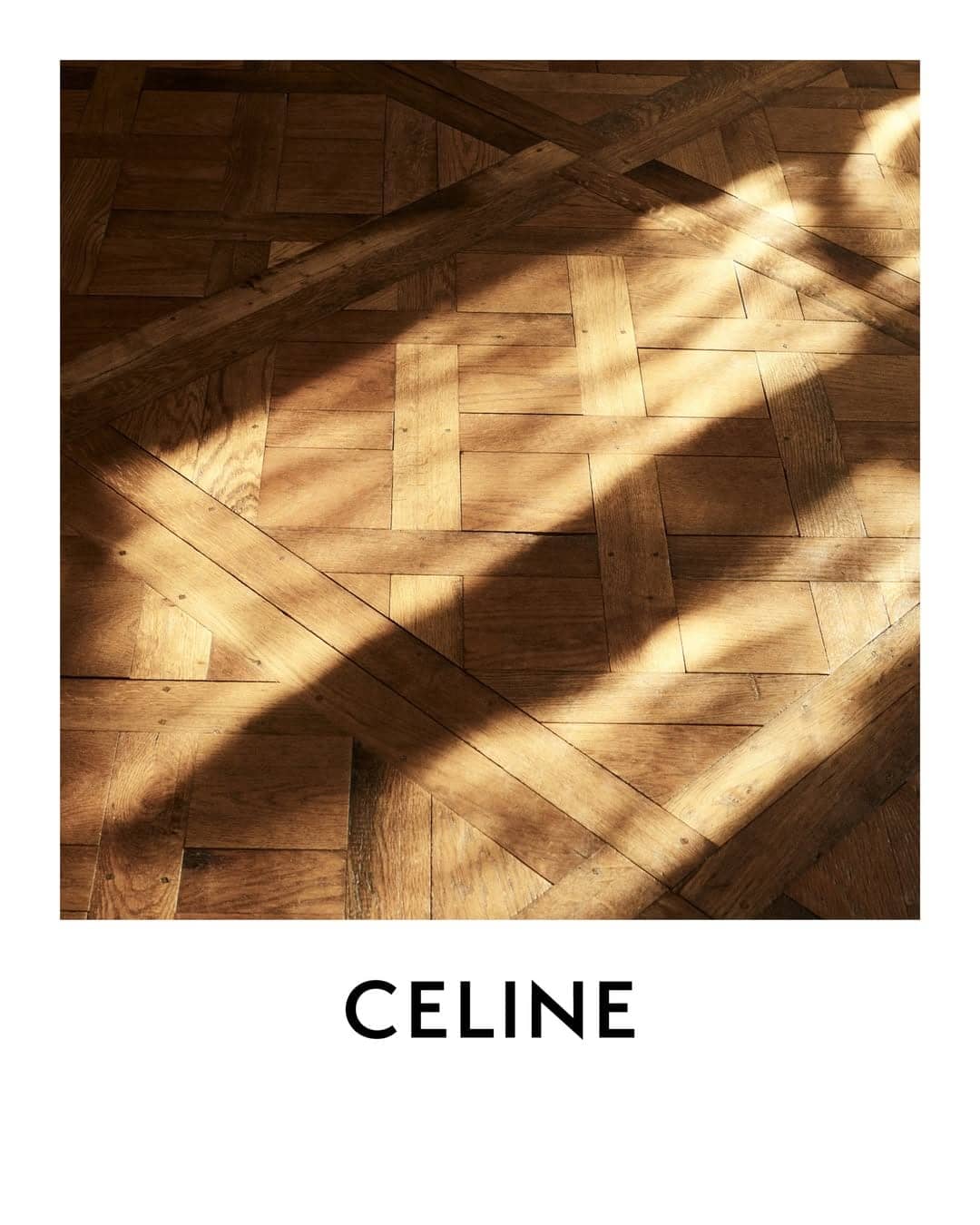 Wood parquet floor with diagonal beams and sunlight casting sharp shadows from above