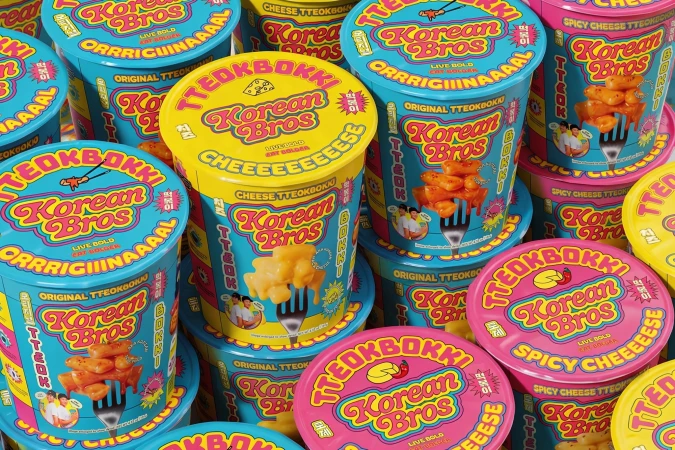 Colorful packaging design for Korean Bros tteokbokki cups featuring vibrant pink yellow and blue containers.