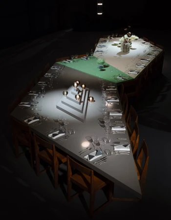 High-angle shot of a long geometric dining table featuring segmented color sections and dramatic spotlighting in a dark room